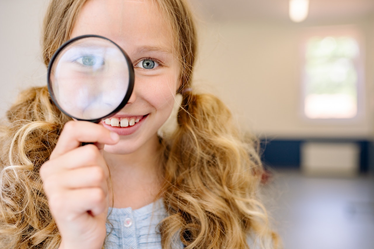 Girl holding a magnifying glass